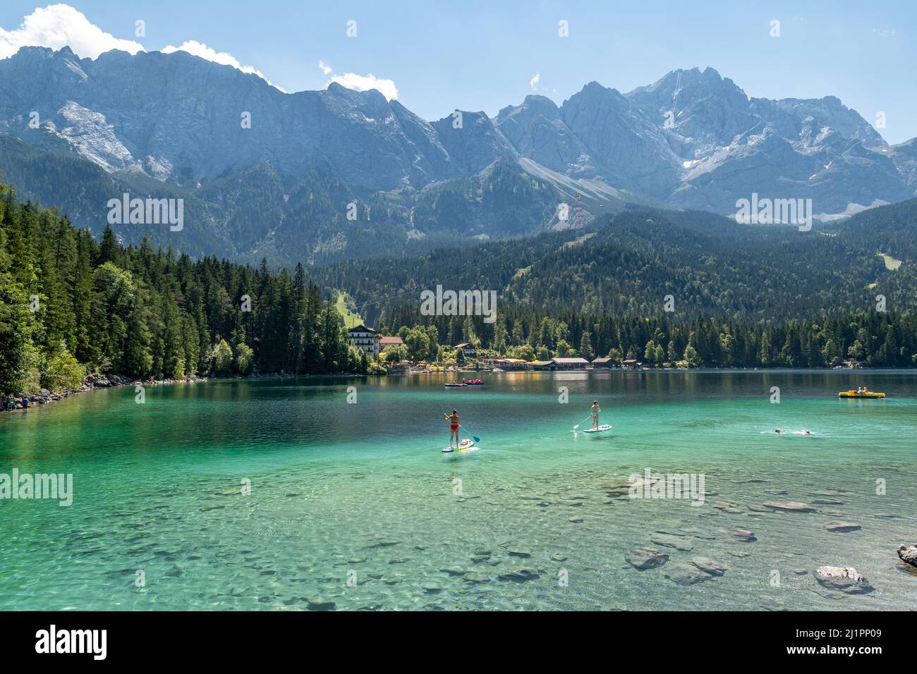 Der deutsche Bergsee Eibsee mit klarem Wasser und Menschen auf ihren