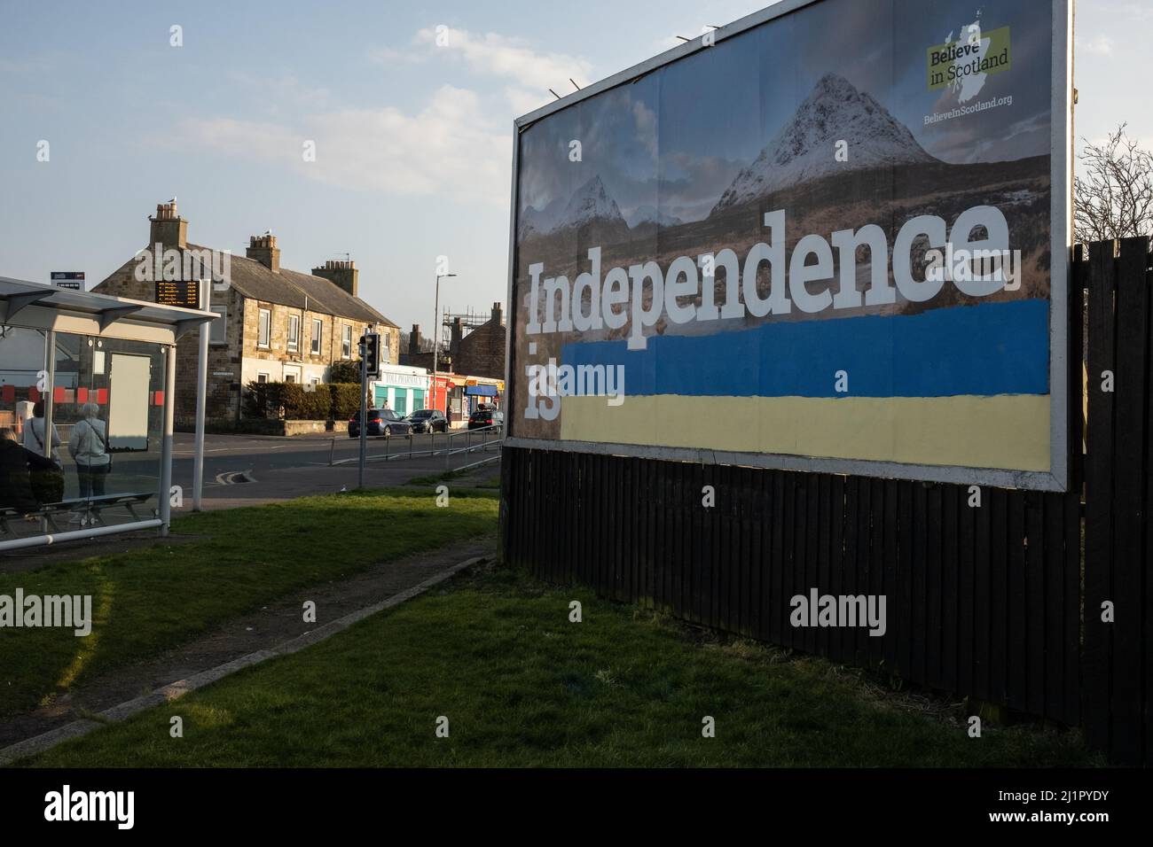 Prestwick, Schottland, 27. März 2022. Eine Plakatwand, auf der jemand die Farben der ukrainischen Flagge gemalt hat, um den Werbeslogan der Pro-schottischen Unabhängigkeit mit der Aufschrift ÒIndependence is normalÓ von der Kampagne „Believe in Scotland“ in eine proukrainische Botschaft zu verwandeln, die die Unterstützung für das vom Krieg zerrissene Land zeigt, während es von Russland in Prestwick eingedrungen wird, Schottland, Den 27. März 2022. Foto: Jeremy Sutton-Hibbert/Alamy Live News. Stockfoto