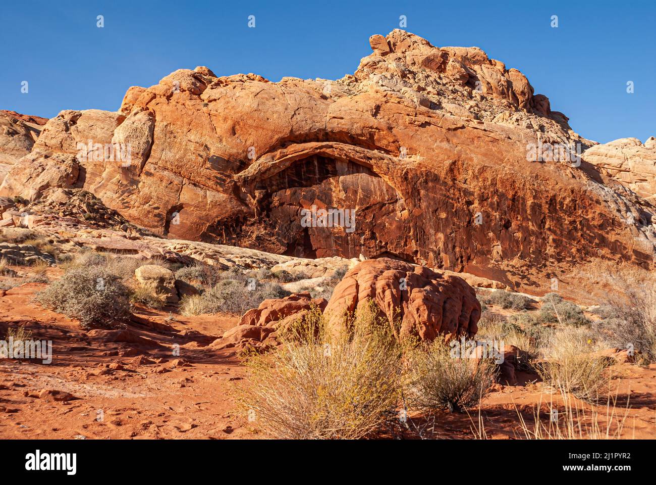 Overton, Nevada, USA - 11. Dezember 2010: Valley of Fire. Lanscape mit natürlichem Bogen auf roten Felsen der Bergkette unter blauem Himmel. Wüstenboden Stockfoto