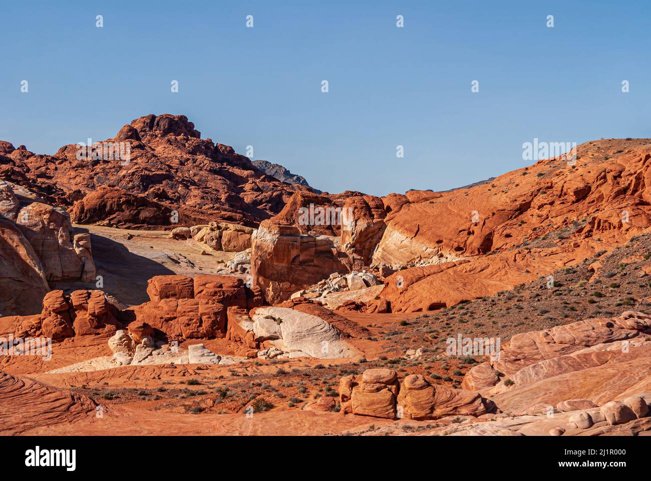 Overton, Nevada, USA - 11. Dezember 2010: Valley of Fire. Landschaft von intensiven roten felsigen Berg durch ein paar hellgraue Flecken unter blauem Himmel versetzt. Stockfoto