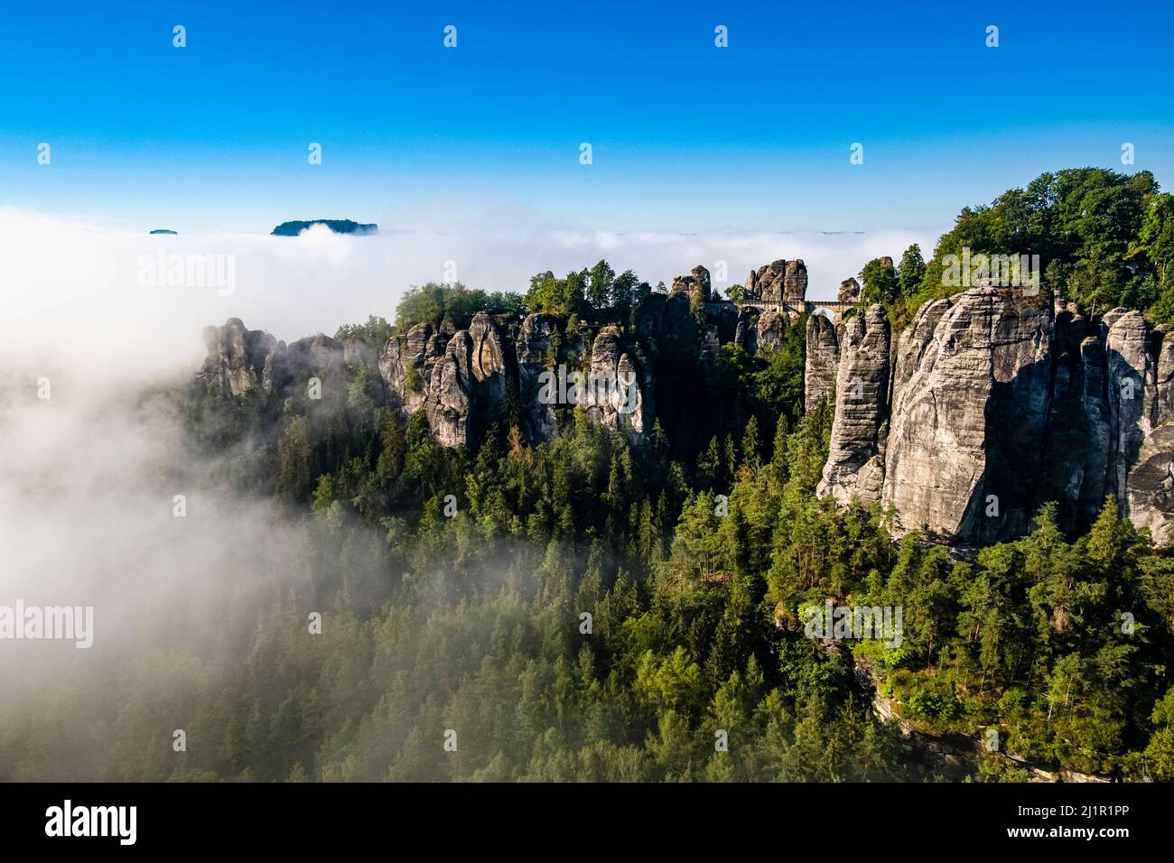 Landschaft mit den nebelbedeckten Felsformationen Felsenburg Neurathen und Bastei im Gebiet Rathen des Nationalparks Sächsische Schweiz. Stockfoto