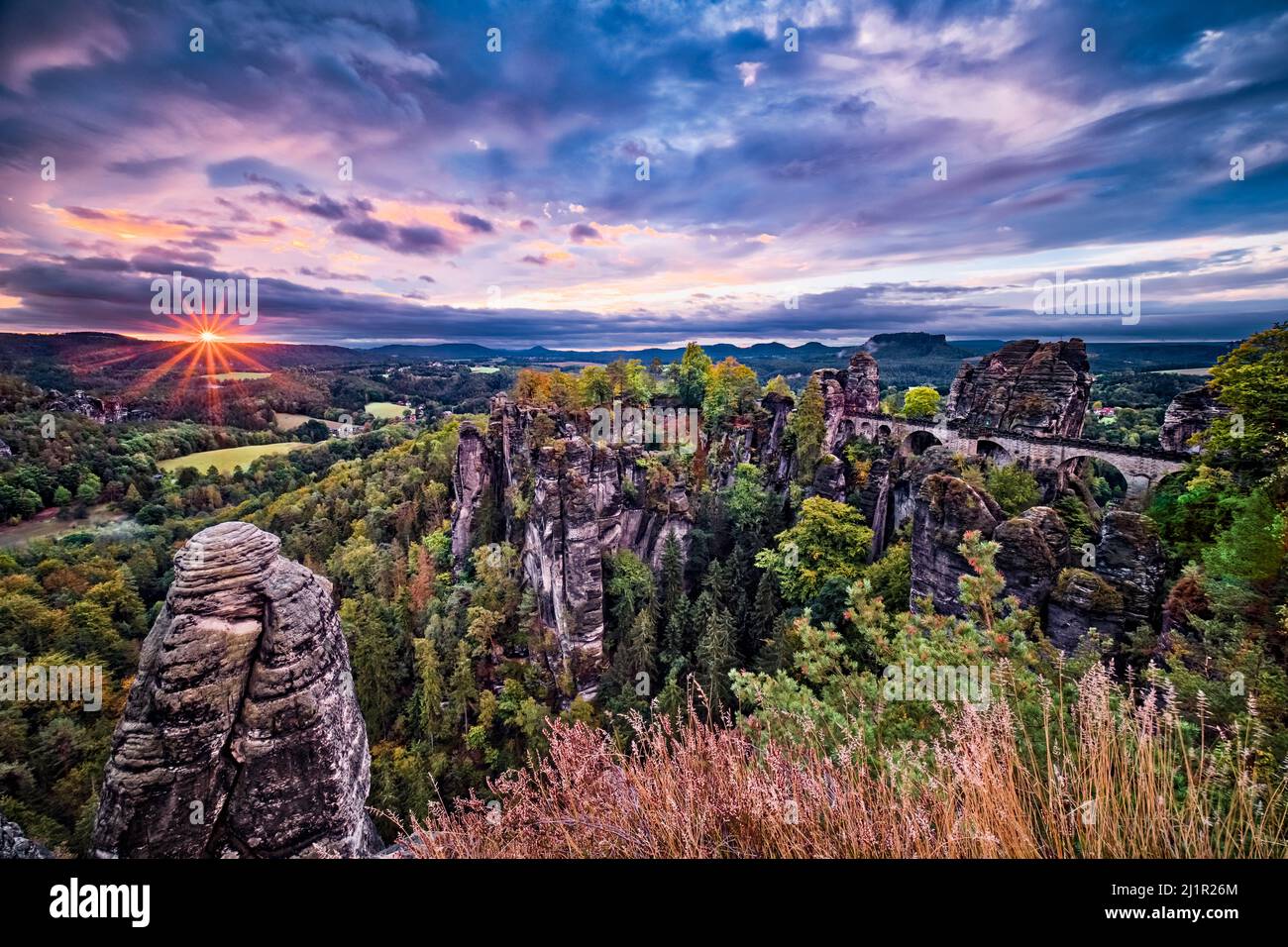Landschaft mit den Felsformationen Felsenburg Neurathen und Bastei im Rathen-Gebiet des Nationalparks Sächsische Schweiz bei Sonnenaufgang. Stockfoto