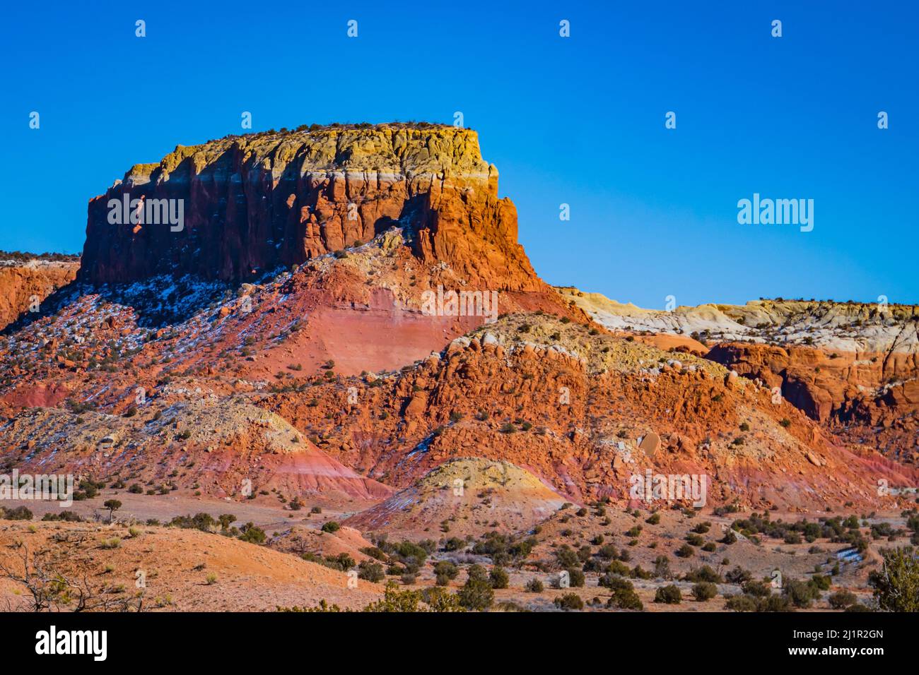 Mesa mit bunten Sandstein- und Gipsschichten, die nach der Erosion im Laufe der Zeit freigelegt wurden Stockfoto