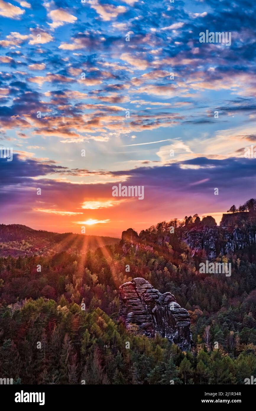 Landschaft mit Felsformationen und bunten Bäumen im Rathen-Gebiet des Nationalparks Sächsische Schweiz im Herbst bei Sonnenuntergang. Stockfoto