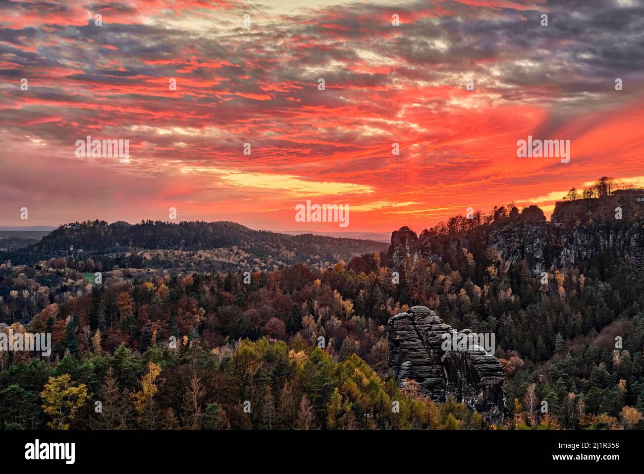 Landschaft mit Felsformationen und bunten Bäumen im Rathen-Gebiet des Nationalparks Sächsische Schweiz im Herbst bei Sonnenuntergang. Stockfoto