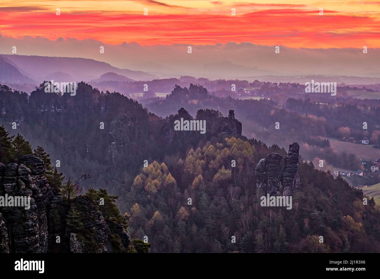 Landschaft mit Felsformationen und bunten Bäumen im Rathen-Gebiet des Nationalparks Sächsische Schweiz bei Sonnenaufgang im Herbst. Stockfoto