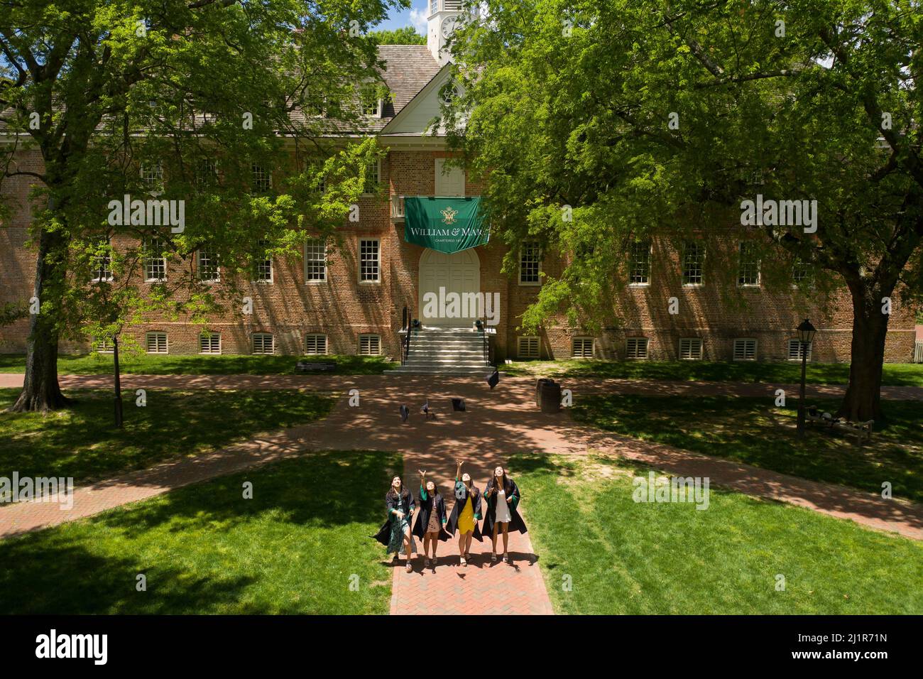 Hochschulabsolventen feiern vor dem Wren Building an der William and Mary University in Williamsburg, VA Stockfoto