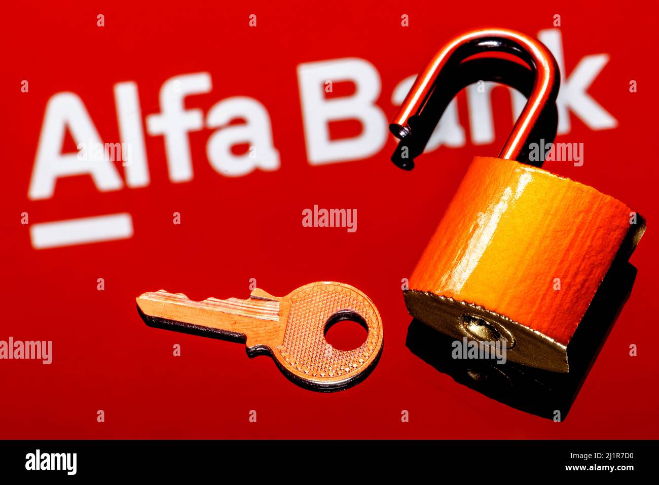 Ein offenes Sicherheitsschloss und Schlüssel auf dem Hintergrund des Alfa Bank Logos in Spiegelreflexion Stockfoto