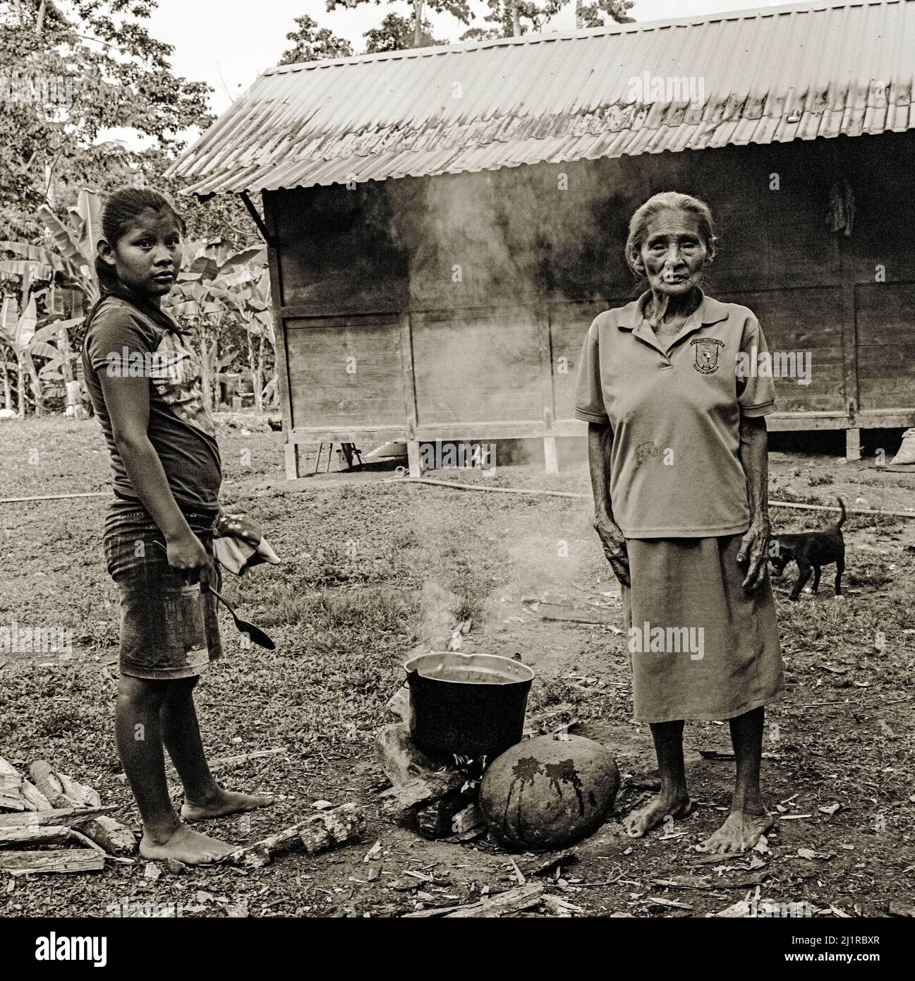 Großmutter des indigenen Stammes der Cabecar in Costa Rica, die über offenem Feuer kocht Stockfoto