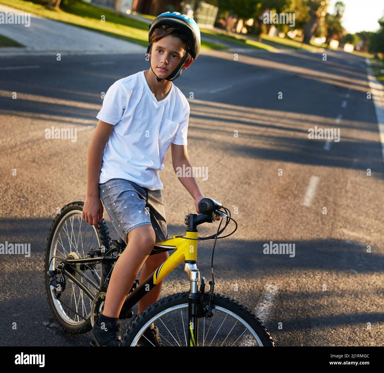 Durch seinen Block radeln. Aufnahme eines Jungen, der mit dem Fahrrad durch seine Nachbarschaft fährt. Stockfoto