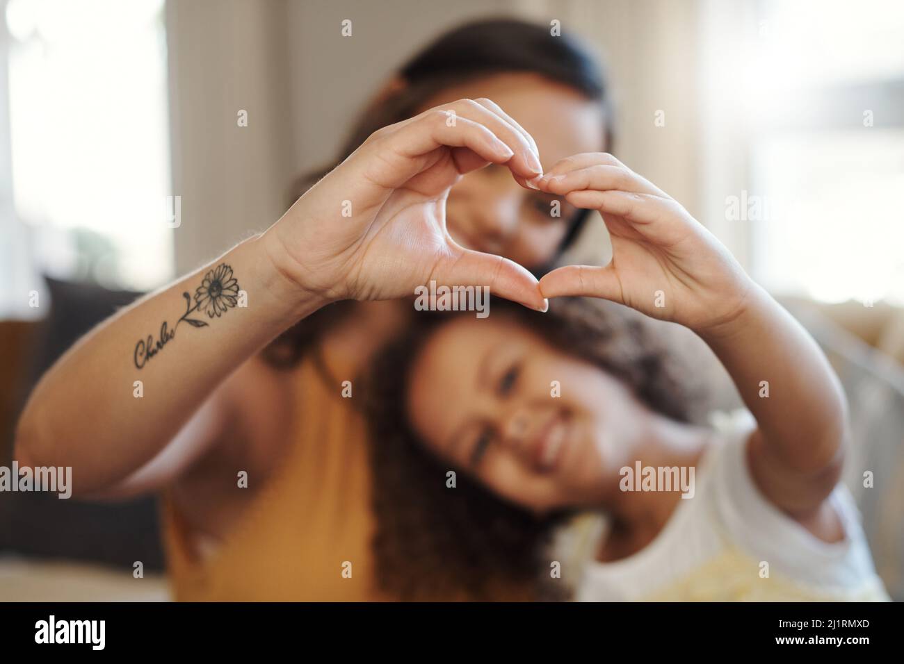 Wir haben viel Liebe zu teilen. Aufnahme einer unkenntlichen Frau, die sich zu Hause mit ihrer Tochter verbunden und eine herzförmige Geste macht. Stockfoto