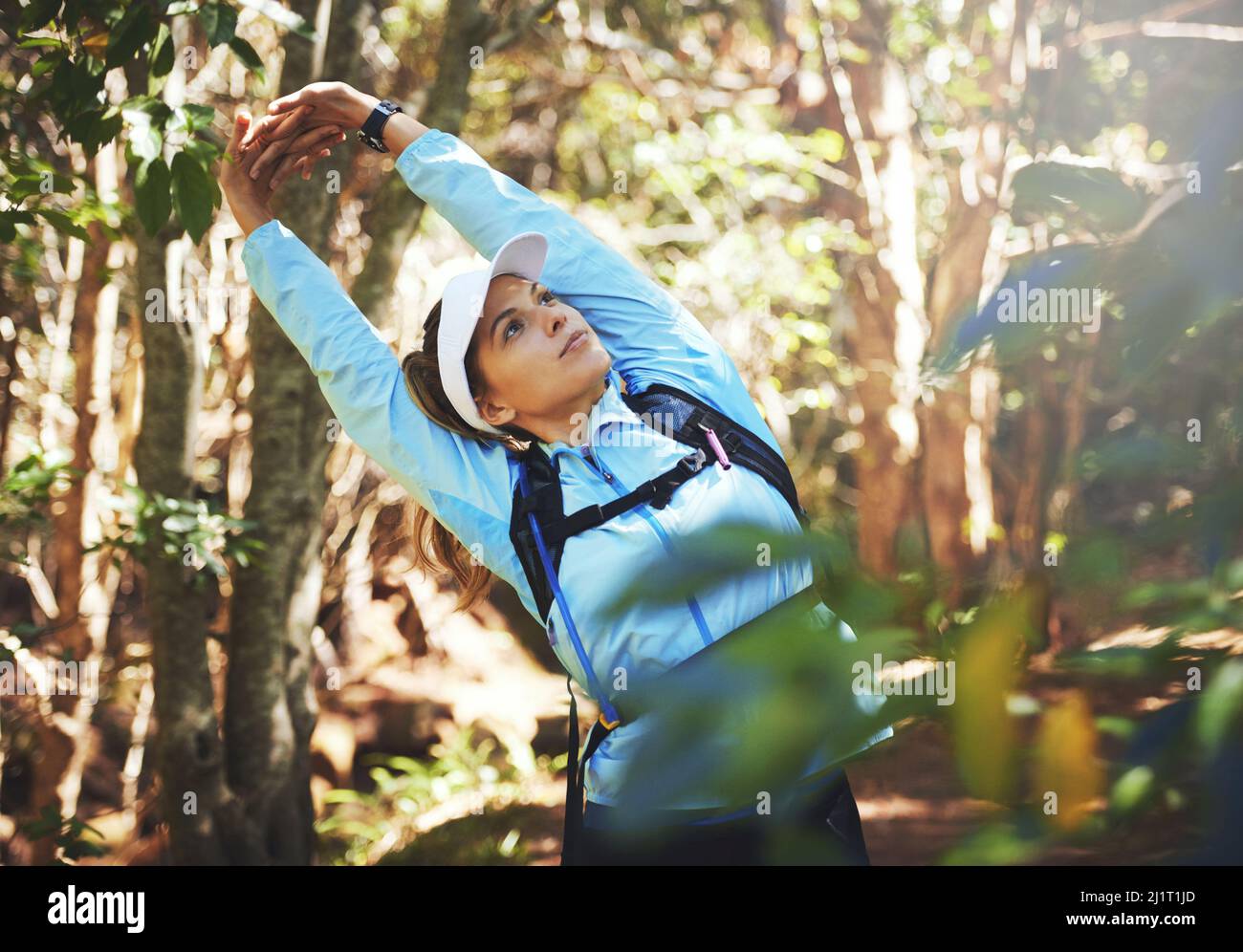 Bleib limber, Bleib schnell. Aufnahme einer jungen Frau, die sich für einen Trail-Lauf aufwärmt. Stockfoto