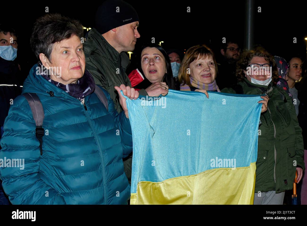 Neben der ukrainischen Flagge stehen mehrere Personen der ukrainischen Nationalität, die aufgrund des Krieges des russischen Angriffs auf die Ukraine in der Stadt Vendrell Zuflucht gesucht haben. Die Vereinigung „DRAC de FOC El Cabrot de El Vendrell“ (Feuerdrache) handelt in einer pyrotechnischen Darstellung in Solidarität und Unterstützung für Menschen ukrainischer Nationalität, die aufgrund der Invasion Russlands in der Ukraine in Hotels und kommunalen Hostels in der Stadt Vendrell Flüchtlinge sind, Die Aufführung von Feuerparaden ist eine katalanische Tradition, die jedes Jahr in Städten und Gemeinden stattfindet. Stockfoto