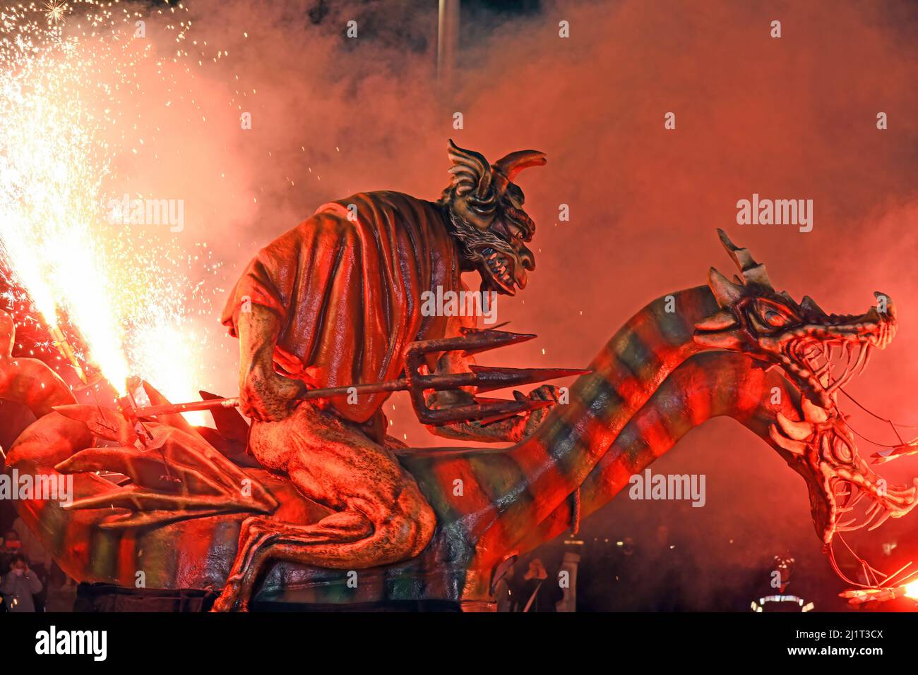 Ein Demonstrator trägt ein Geschöpf in Form eines Drachen, der Feuer atmet, während der pyrotechnischen Demonstration in Solidarität mit ukrainischen Flüchtlingen in Vendrell. Die Vereinigung „DRAC de FOC El Cabrot de El Vendrell“ (Feuerdrache) handelt in einer pyrotechnischen Darstellung in Solidarität und Unterstützung für Menschen ukrainischer Nationalität, die aufgrund der Invasion Russlands in der Ukraine in Hotels und kommunalen Hostels in der Stadt Vendrell Flüchtlinge sind, Die Aufführung von Feuerparaden ist eine katalanische Tradition, die jedes Jahr in Städten und Gemeinden stattfindet. Stockfoto