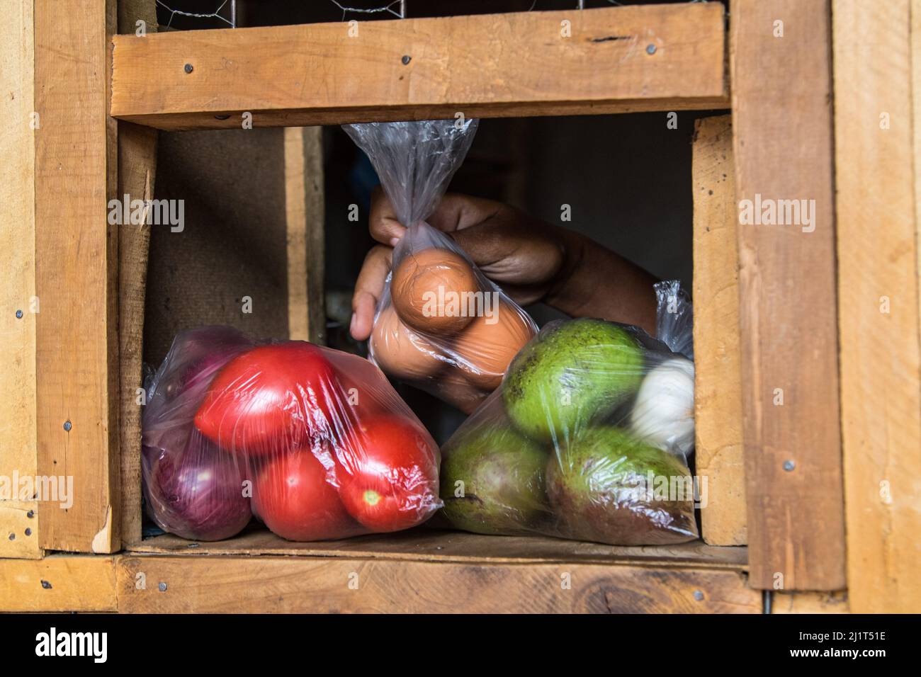Eine Ladenbesitzerin versorgt ihre Kundin mit Eiern, Obst und Gemüse, die in verbotenen Plastiktüten verpackt sind. Am 28 2017. August Verbot Kenia die Verwendung, Herstellung und Einfuhr aller Einweg-Plastiktüten, die für gewerbliche Verpackungen und Haushaltsverpackungen verwendet werden. Das weltweit als strengstes Verbot gepriesen wurde leider dadurch frustriert, dass Händler die Taschen durch Kenias poröse Grenzen mit seinen ostafrikanischen Nachbarn schmuggeln. Umweltgruppen haben sich für ein regionales Verbot von Einweg-Kunststoff eingesetzt, um die zunehmende Verschmutzung durch Kunststoff einzudämmen. (Foto von James Wakibia/SOPA Images/Sipa USA) Stockfoto