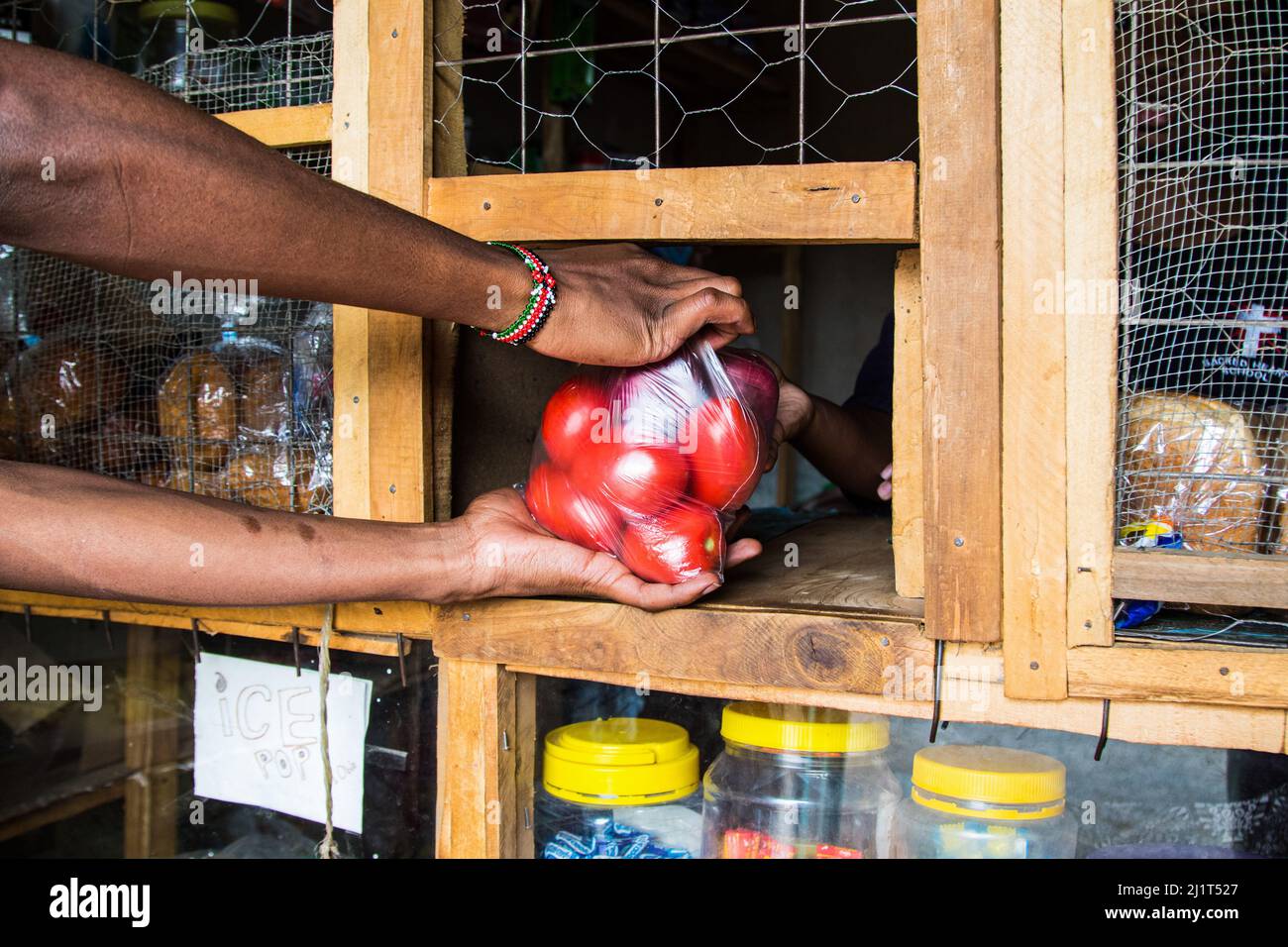 Eine Ladenbesitzerin versorgt ihre Kundin mit Obst und Gemüse, die in verbotenen Plastiktüten verpackt sind. Am 28 2017. August Verbot Kenia die Verwendung, Herstellung und Einfuhr aller Einweg-Plastiktüten, die für gewerbliche Verpackungen und Haushaltsverpackungen verwendet werden. Das weltweit als strengstes Verbot gepriesen wurde leider dadurch frustriert, dass Händler die Taschen durch Kenias poröse Grenzen mit seinen ostafrikanischen Nachbarn schmuggeln. Umweltgruppen haben sich für ein regionales Verbot von Einweg-Kunststoff eingesetzt, um die zunehmende Verschmutzung durch Kunststoff einzudämmen. (Foto von James Wakibia/SOPA Images/Sipa USA) Stockfoto
