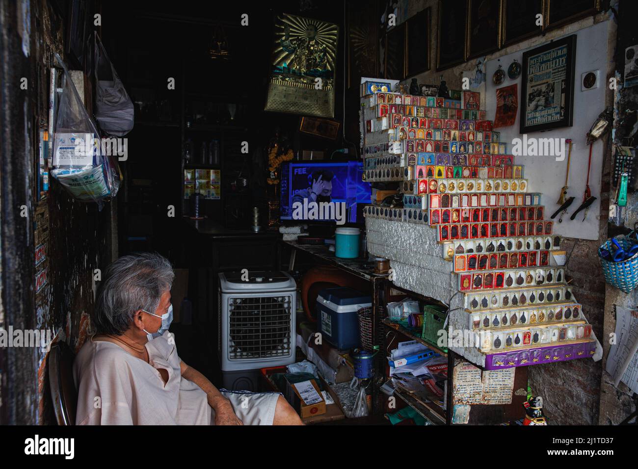 Bangkok, Thailand. 17. März 2022. Ein alter Mann sah in seinem Phra Krueng (Buddha Amulett) in Bangkoks Innenzone Fernsehen. Rattanakosin Island, das Innere Bangkoks, ist der Kern der historischen und kulturellen Zone Bangkoks. Dieser Ort ist auch bekannt als eine alte Stadt wegen des Alters der Zone, dass mehr als 100 Jahre des Bestehens. Nicht nur Palast, Tempel und Wahrzeichen dieser Zone umfassen das Leben und die Aktivitäten der Menschen, die rund um die heilige Gegend von Bangkok leben. (Bild: © Varuth Pongsapipatt/SOPA Images via ZUMA Press Wire) Stockfoto