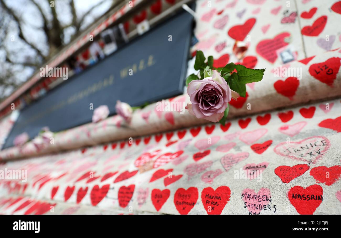 London, Großbritannien. 27. März 2022. Blumen, handgemalte Herzen und Botschaften zum Gedenken an die Opfer der COVID-19-Pandemie sind am 27. März 2022 an der National COVID Memorial Wall in London, Großbritannien, zu sehen. Kredit: Li Ying/Xinhua/Alamy Live Nachrichten Stockfoto