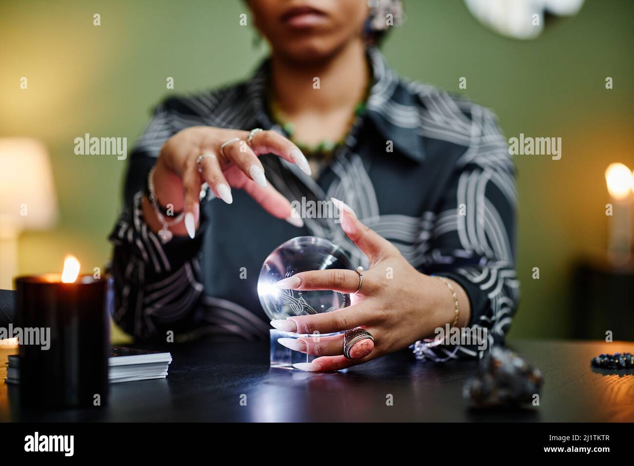 Nahaufnahme des Wahrsagerin, der bei spiritueller Seance in die Kristallkugel blickt, konzentrieren Sie sich auf weibliche Hände, die gestikulieren Stockfoto
