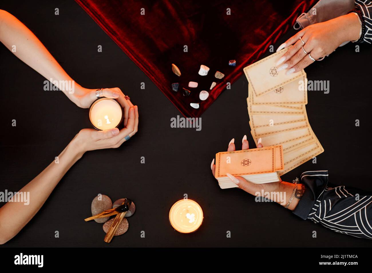 Draufsicht auf weibliche Wahrsagerin beim Lesen von Tarot-Karten für junge Frau, die bei spiritueller Seance zu Besuch ist Stockfoto