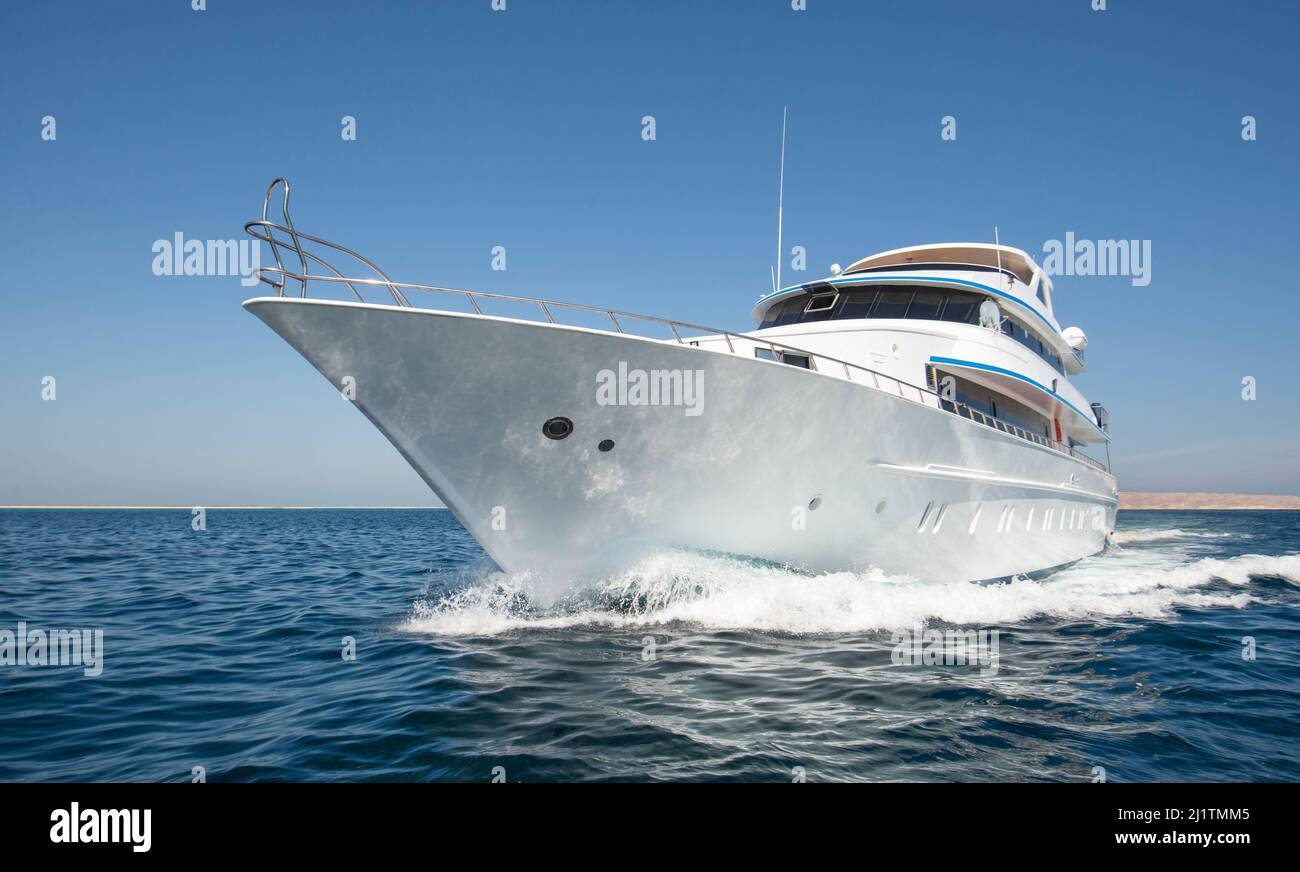 Luxuriöse private Motoryacht, die auf tropischem Meer mit Bugwelle segelt Stockfoto