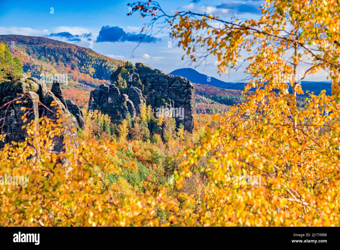 Landschaft mit Felsformationen, bunten Bäumen und dem Gipfel Rauschenstein im Schmilka-Gebiet des Nationalparks Sächsische Schweiz im Herbst. Stockfoto
