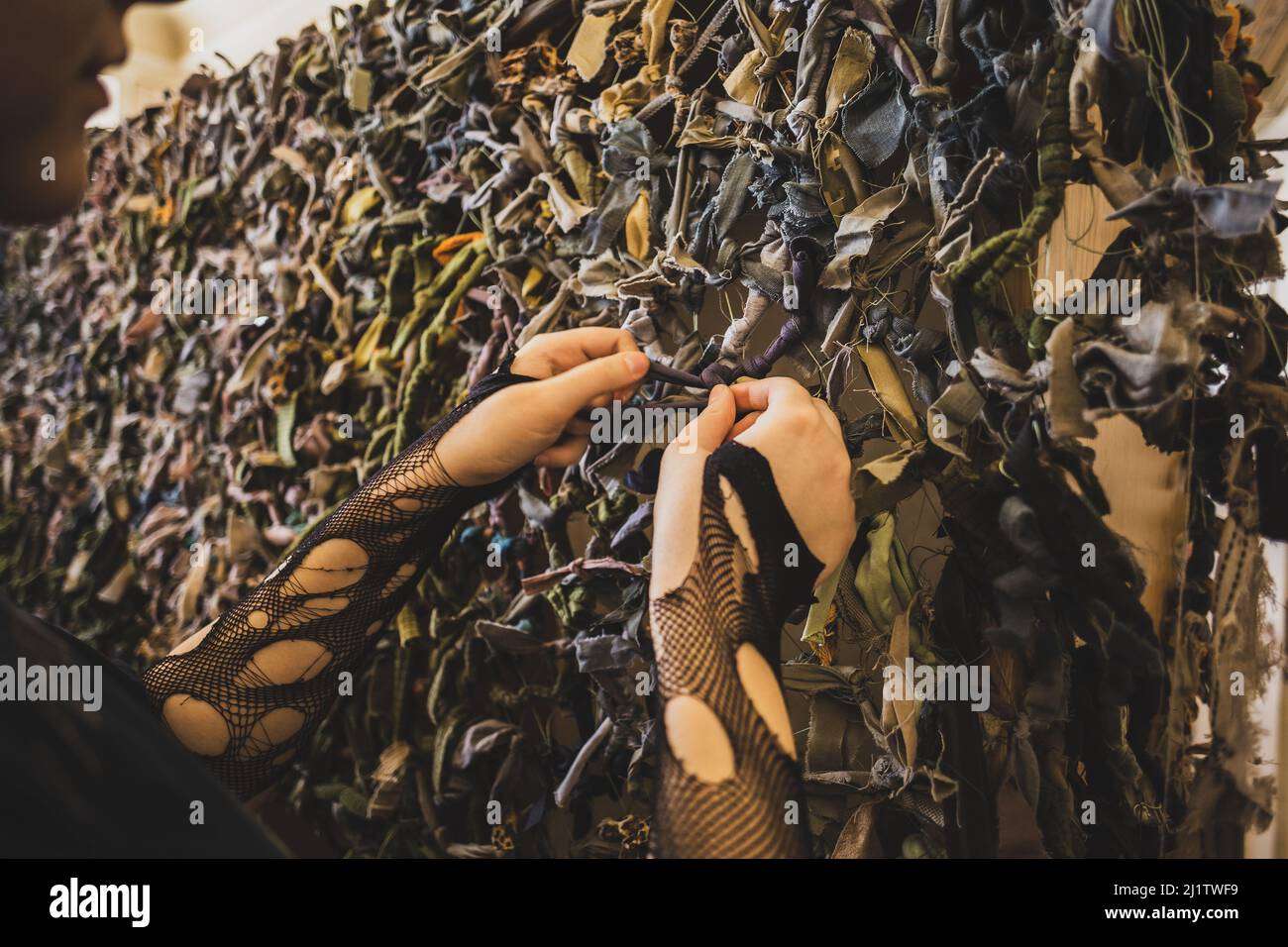 LVIV, UKRAINE - 17. März 2022: Freiwillige Hände wegenden Tarnnetz für die ukrainischen Streitkräfte. Handgefertigtes Maskennetz aus naturfarbenem Stockfoto