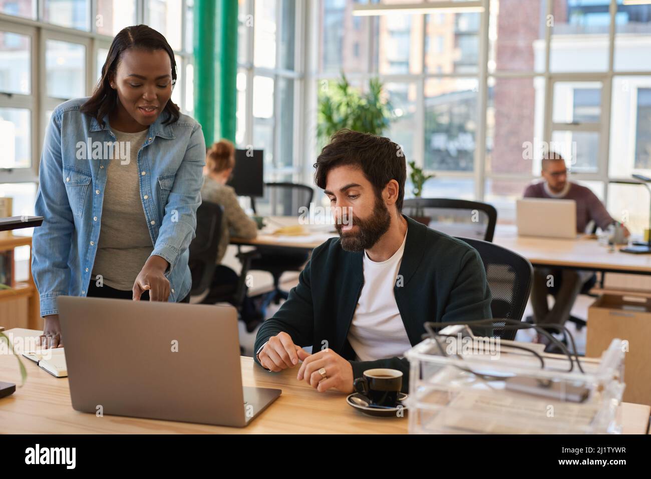Zwei junge Geschäftsleute, die an einem Laptop arbeiten Stockfoto
