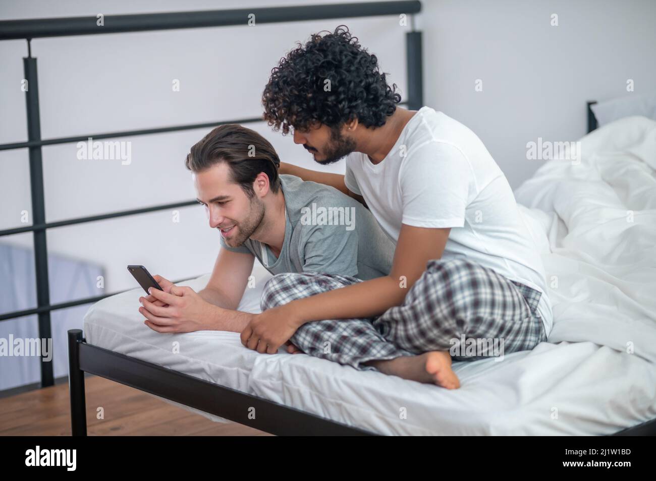 Zwei schwule Männer betrachten Fotos auf dem Smartphone Stockfoto