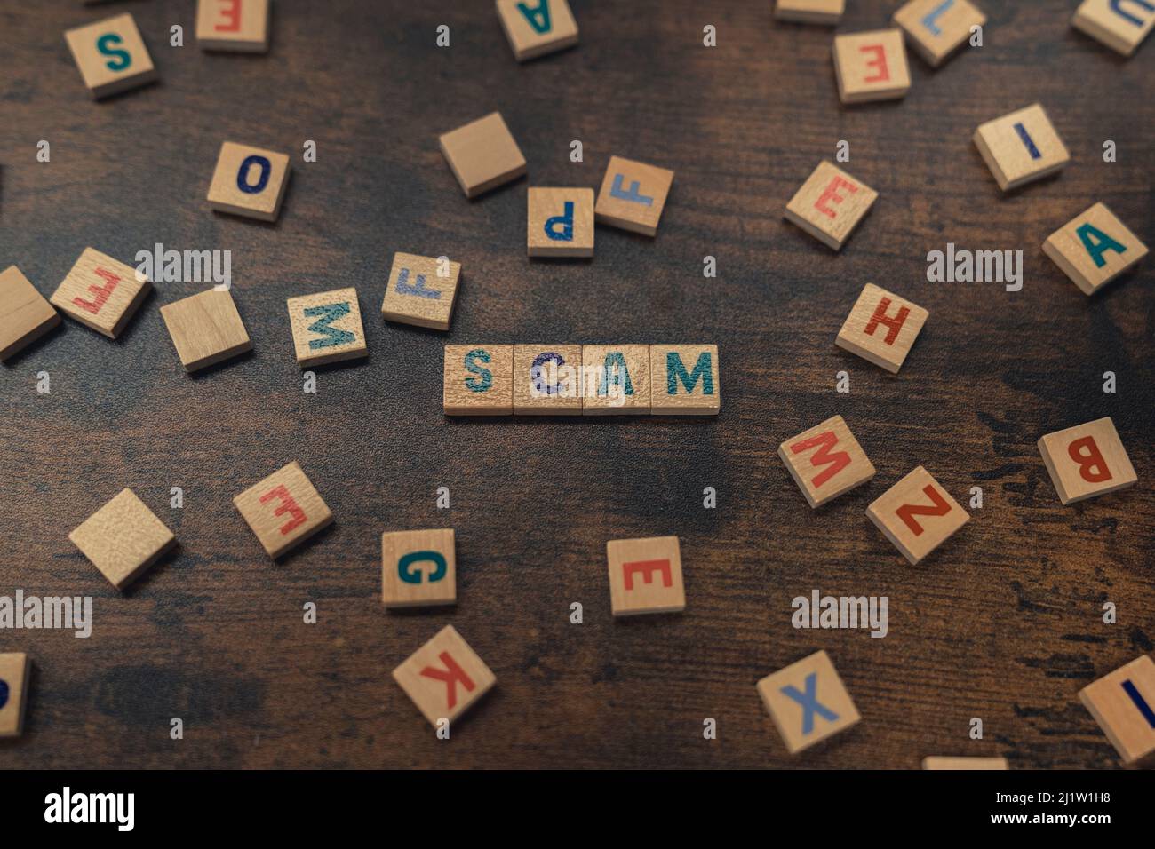 SCAM - ein Wort zusammen mit ausgerichteten Holzklötze mit Buchstaben Sicherheit und Sicherheitskonzept. Hochwertige Fotos Stockfoto