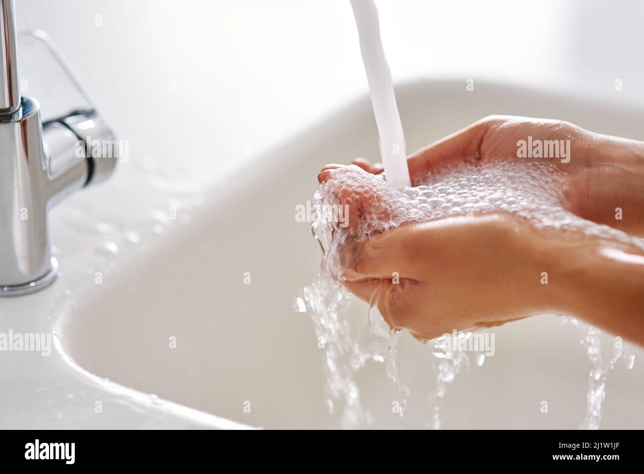 Bleiben Sie gesund, indem Sie Ihre Hände waschen. Abgeschnittene Aufnahme der Hände, die mit fließendem Wasser gewaschen wurden. Stockfoto