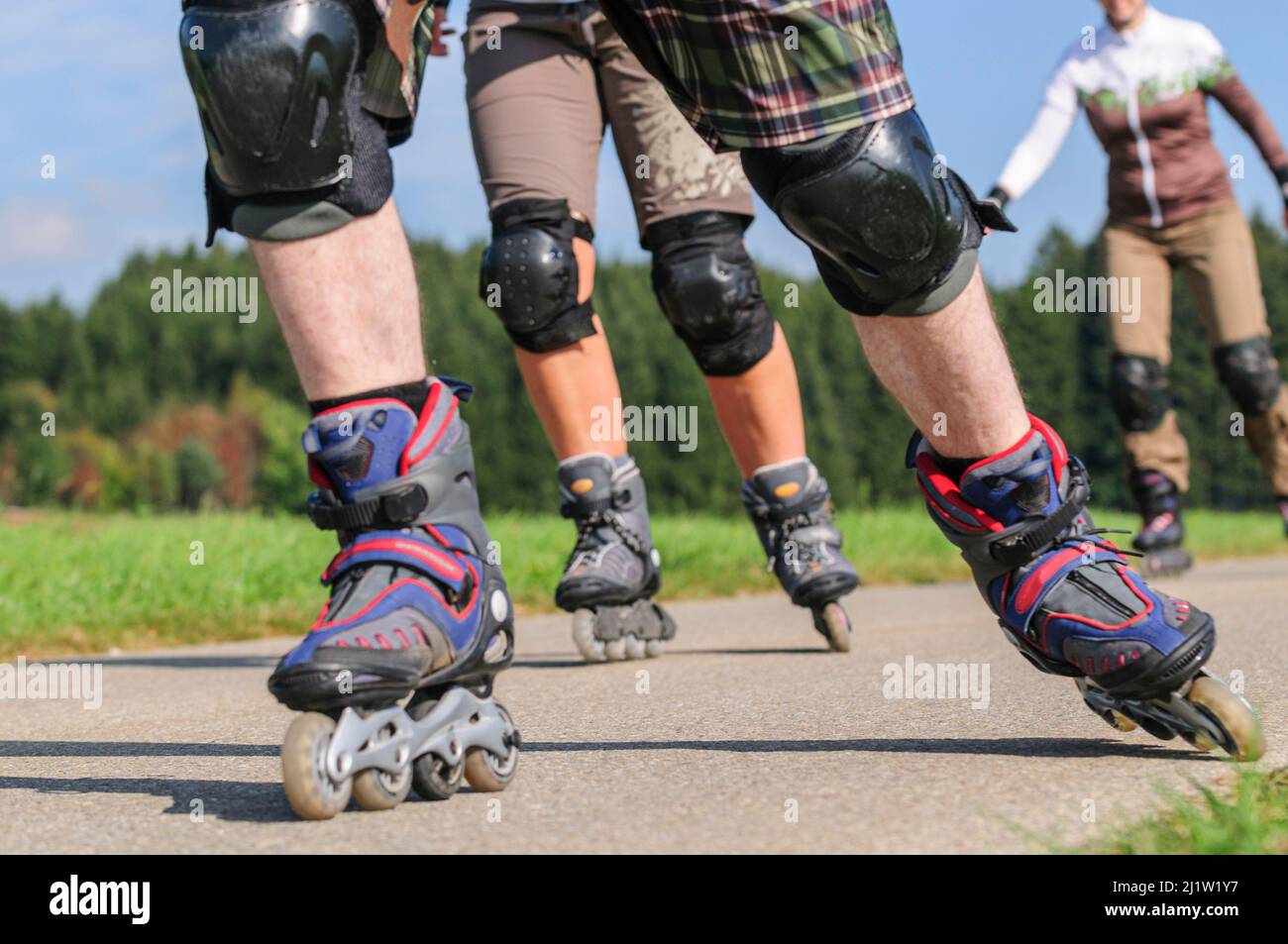 Gruppe, die eine Tour auf Rollerblätter auf einem kleinen Auf dem Land Stockfoto