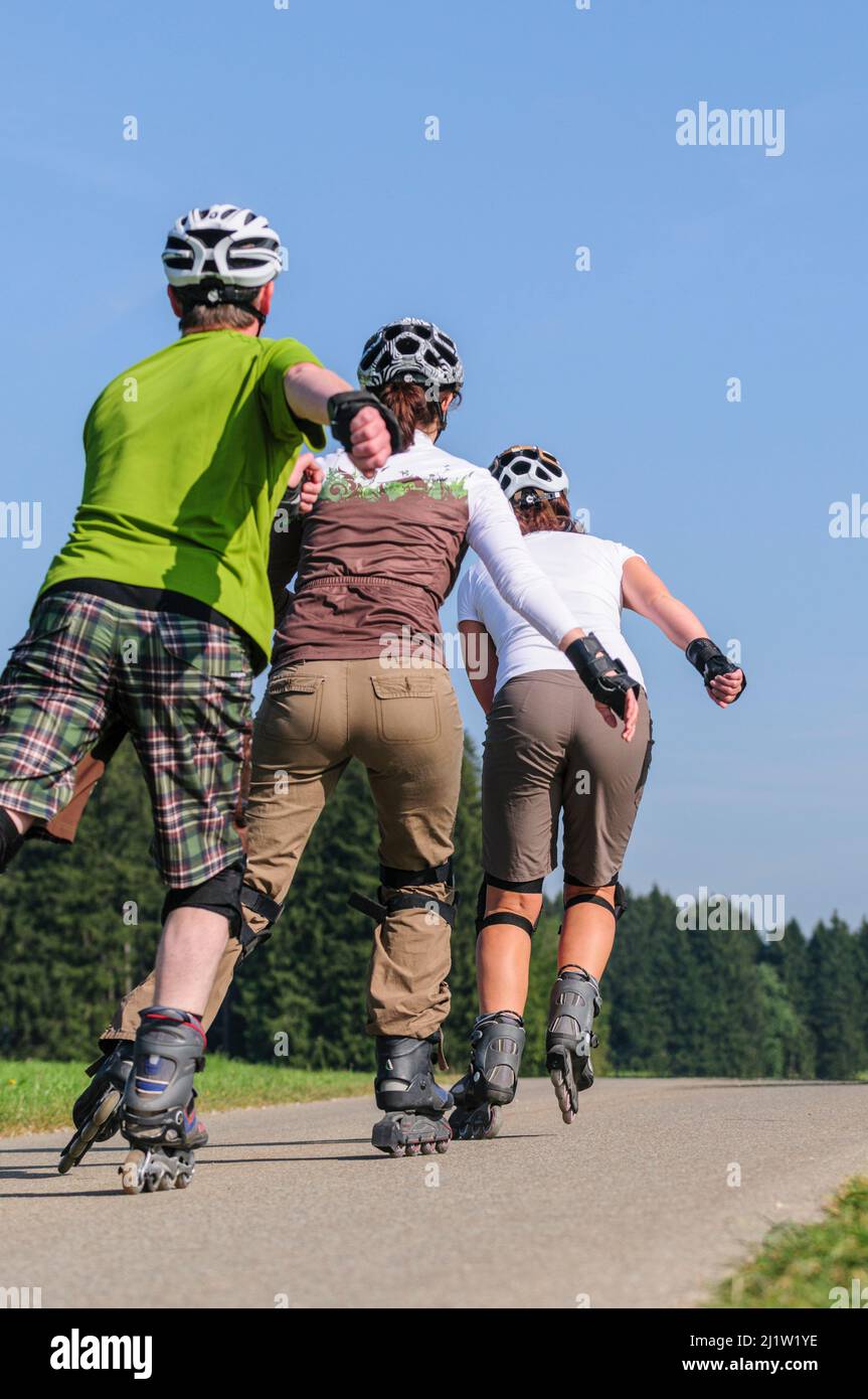 Gruppe, die eine Tour auf Rollerblätter auf einem kleinen Auf dem Land Stockfoto