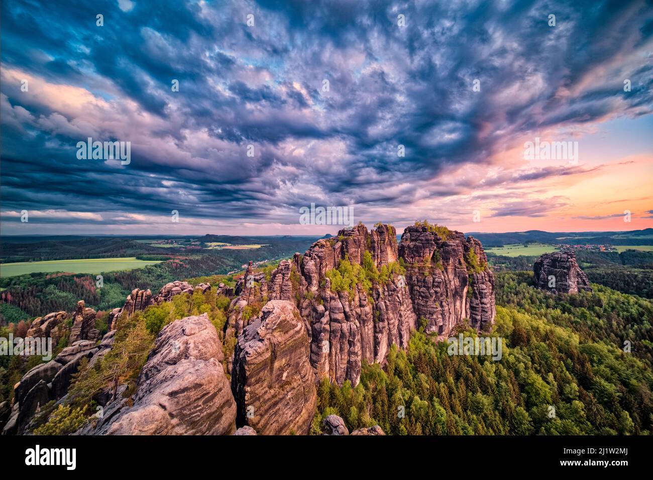 Landschaft mit Felsformationen und den Gipfeln Torstein und Falkenstein im Schrammsteine-Gebiet des Nationalparks Sächsische Schweiz bei Sonnenaufgang. Stockfoto