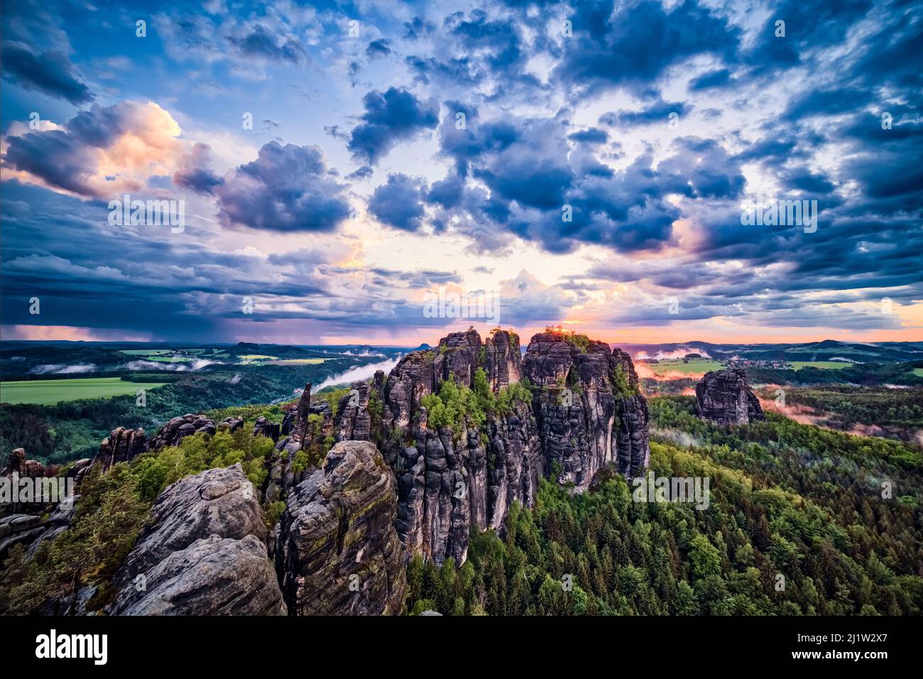 Landschaft mit Felsformationen und den Gipfeln Torstein und Falkenstein im Schrammsteine-Gebiet des Nationalparks Sächsische Schweiz bei Sonnenuntergang. Stockfoto