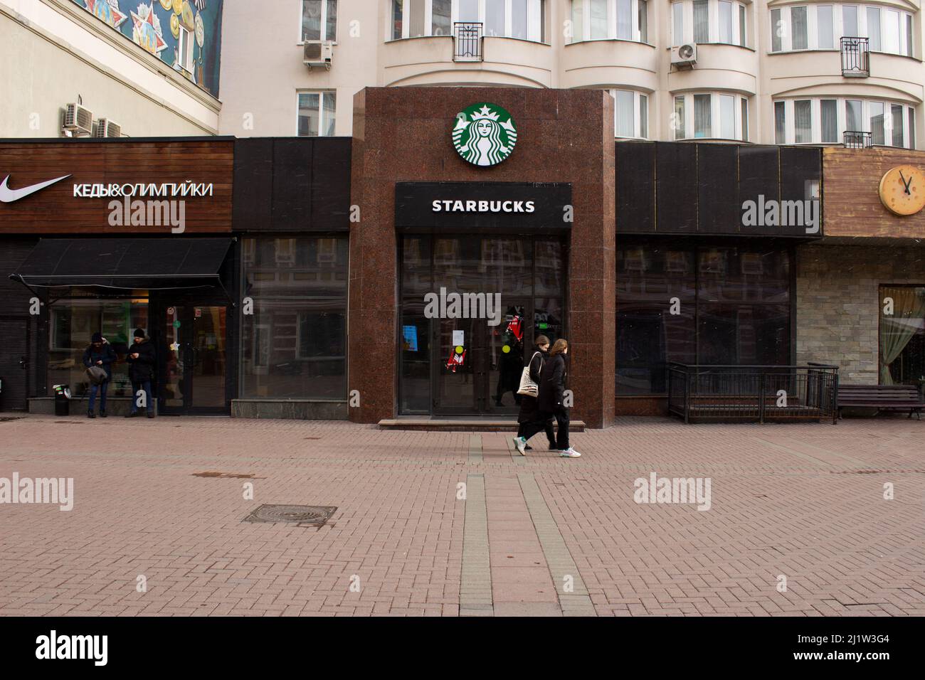 Moskau, Russland. 27. März 2022. Die Menschen gehen an einem geschlossenen Starbucks-Restaurant in Moskau vorbei. Starbucks war eine von vielen ausländischen Marken, die bekannt gaben, dass sie angesichts der militärischen Aktivitäten des Landes in der benachbarten Ukraine ihre Operationen aussetzen würden. Kredit: SOPA Images Limited/Alamy Live Nachrichten Stockfoto