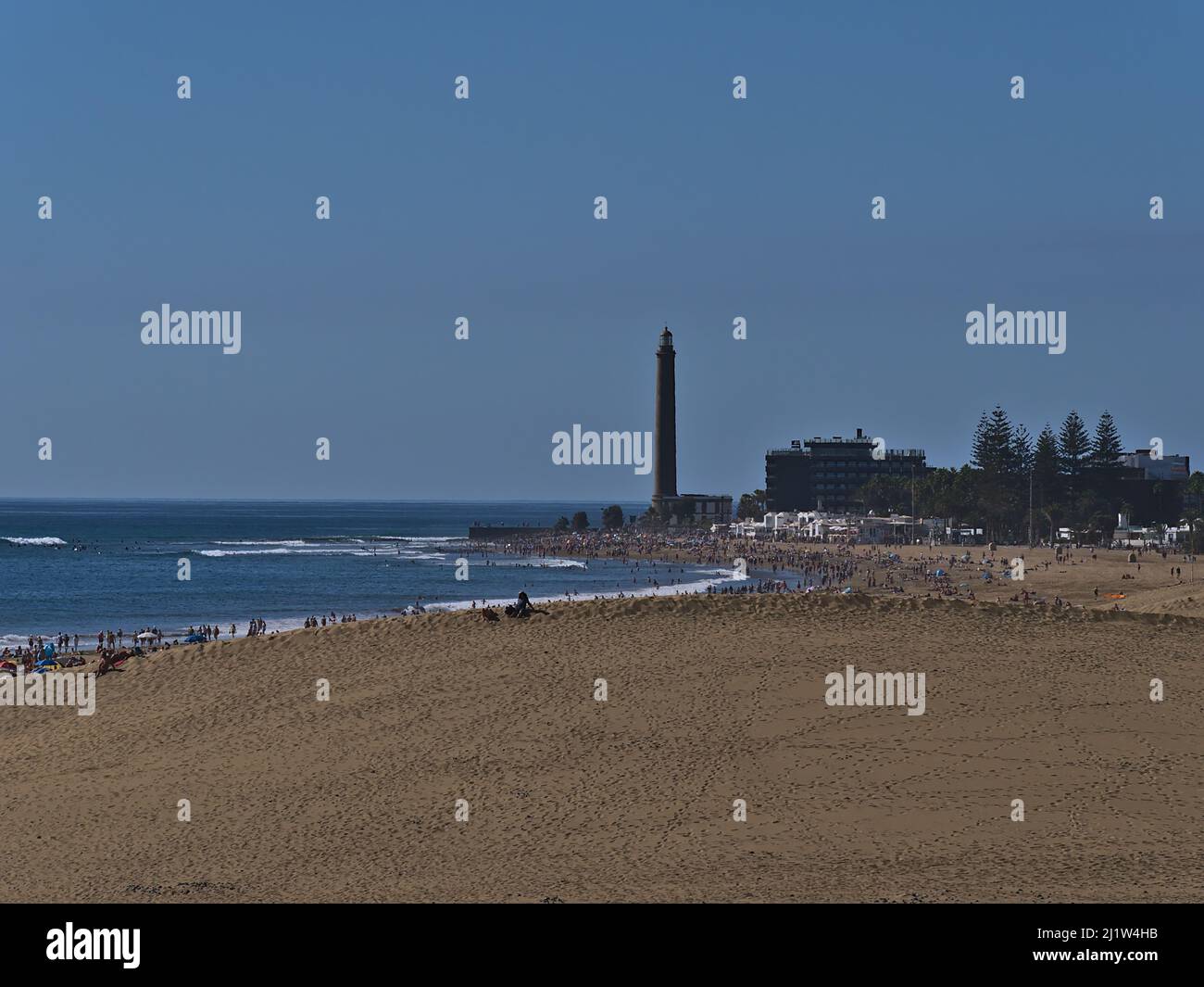 Luftaufnahme über den überfüllten Strand Playa de Maspalomas mit Sanddüne vor dem Strand und Leuchtturm Faro de Maspalomas im Süden von Gran Canaria, Spanien. Stockfoto