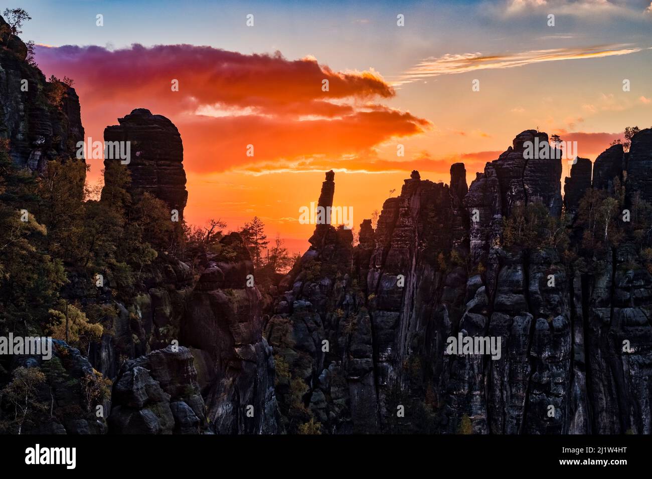 Landschaft mit Felsformationen und dem Gipfel Tante im Schrammsteine-Gebiet des Nationalparks Sächsische Schweiz bei Sonnenuntergang. Stockfoto