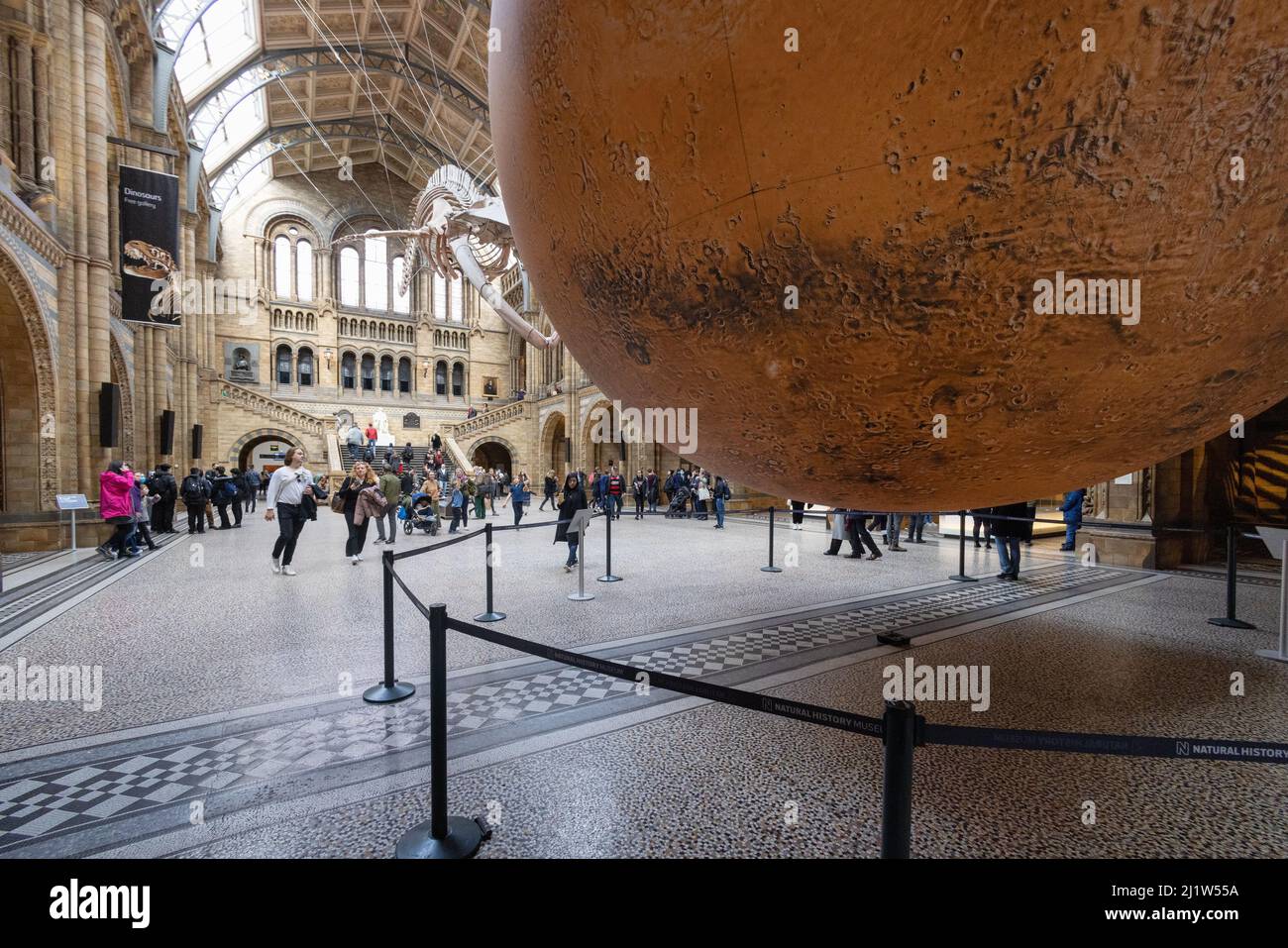 Luke Jerram Mars; Menschen, die das Mars-Kunstmodell von Luke Jerram in der Haupthalle des Natural History Museum, London, Großbritannien, betrachten Stockfoto