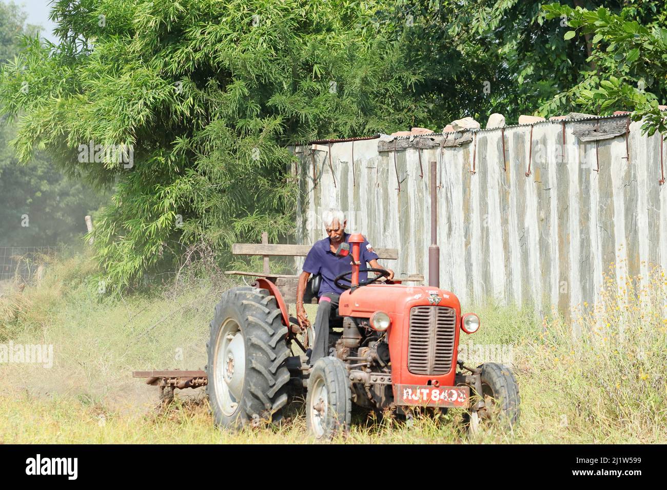 Pali Rajasthan, Indien. 04. November ,2021.Nahaufnahme eines Bauern, der auf einem Traktor sitzt, der mit einem Pflug das Feld pflügt Stockfoto