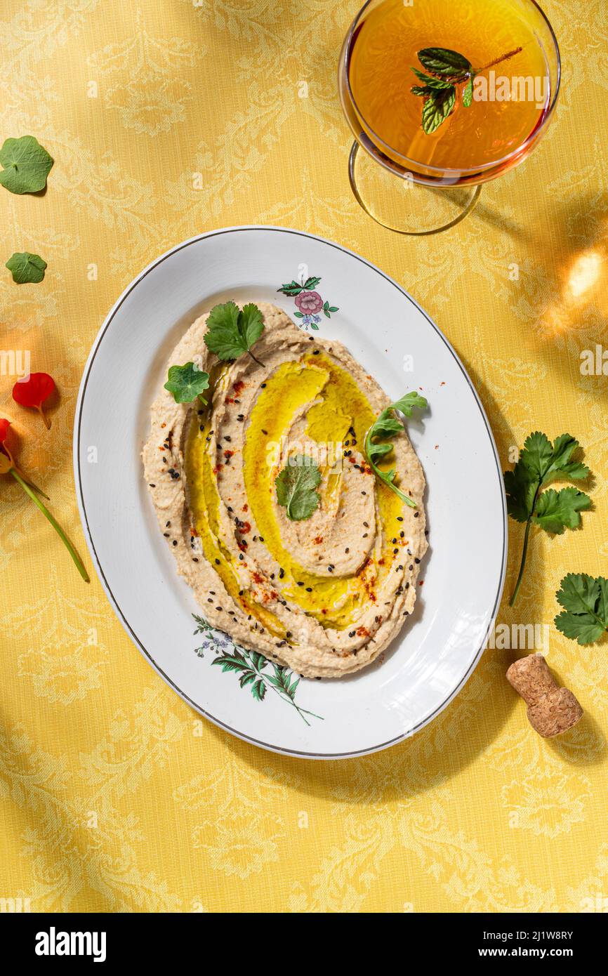 Draufsicht auf Hummus Nahost-herzhaftes Gericht aus pürierten Kichererbsen, gemischt mit Tahini-Zitronensaft und Knoblauch, garniert mit Olivenöl und Grün Stockfoto