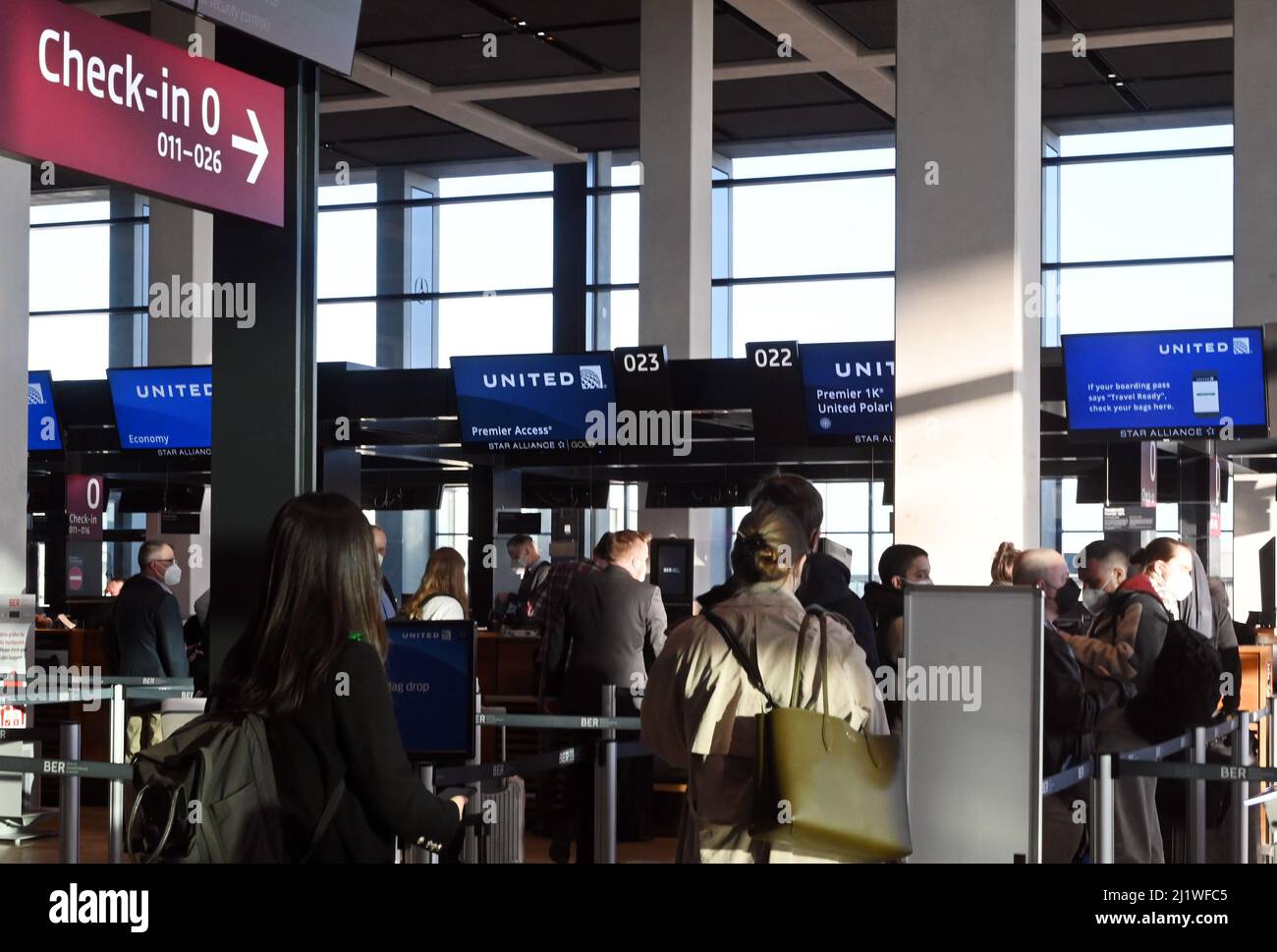 28. März 2022, Brandenburg, Schönefeld: Passagiere warten am Flughafen BER vor den Check-in-Schaltern von United Airlines. Auf Flügen an die US-Ostküste müssen Berliner und Brandenburger nicht mehr unbedingt das Flugzeug wechseln. Ab Montag verbindet United Airlines Schönefeld täglich direkt mit dem New Yorker Flughafen Newark. Dies ist die erste Langstreckenverbindung vom BER in die USA. Foto: Bernd Settnik/dpa-Zentralbild/dpa Stockfoto