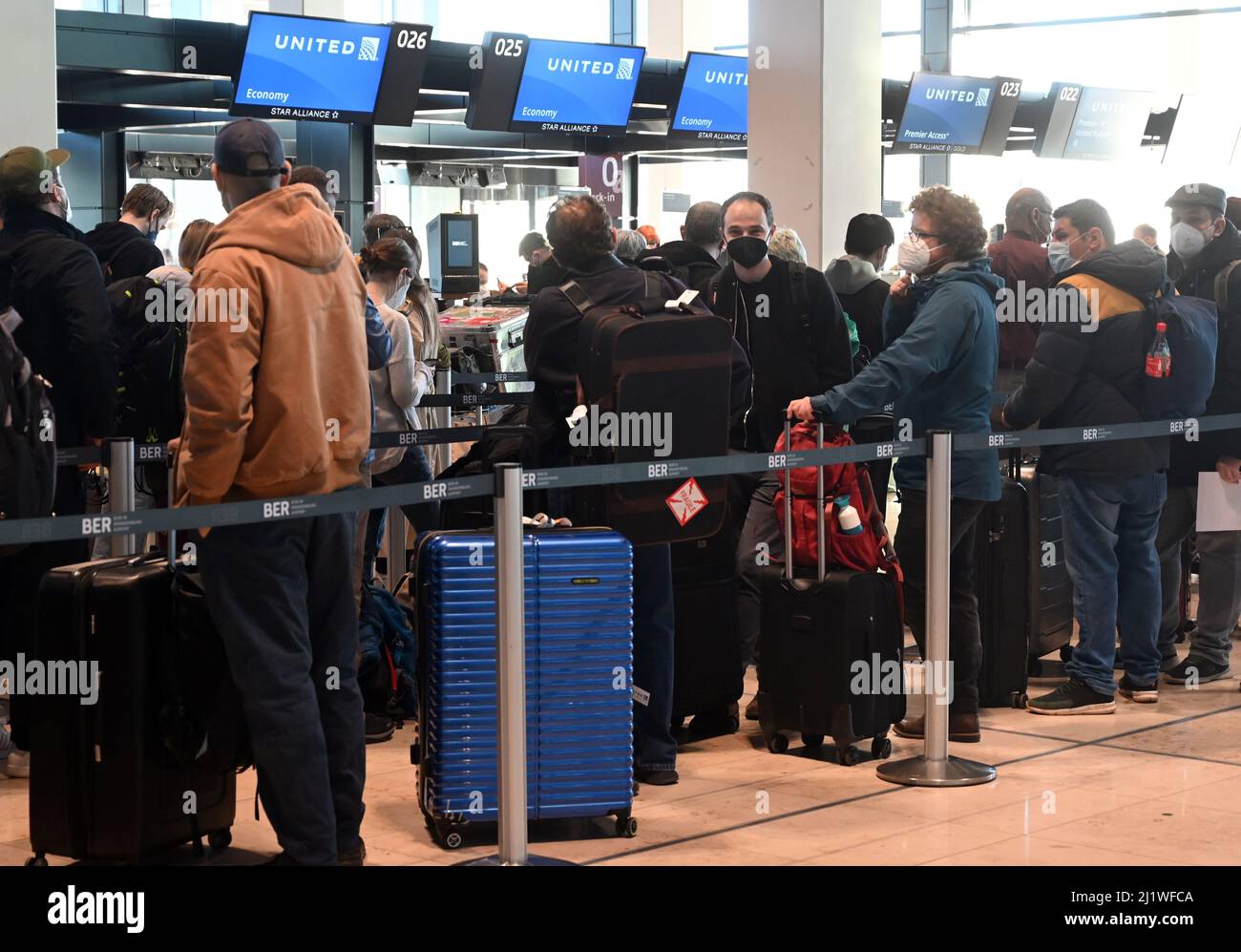 28. März 2022, Brandenburg, Schönefeld: Passagiere warten am Flughafen BER vor den Check-in-Schaltern von United Airlines. Auf Flügen an die US-Ostküste müssen Berliner und Brandenburger nicht mehr unbedingt das Flugzeug wechseln. Ab Montag verbindet United Airlines Schönefeld täglich direkt mit dem New Yorker Flughafen Newark. Dies ist die erste Langstreckenverbindung vom BER in die USA. Foto: Bernd Settnik/dpa-Zentralbild/dpa Stockfoto
