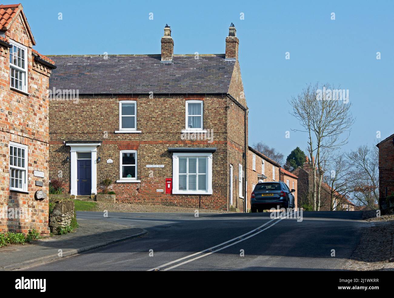 Auto, das an der Kreuzung im Dorf Crayke, North Yorkshire, England, vorbeifährt Stockfoto