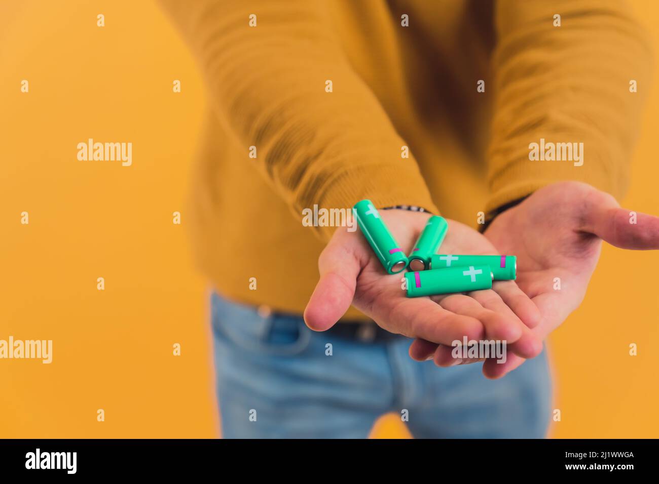 Zwei Handflächen einer kaukasischen Person mit vier Batterien. Ökologie und Recycling-Konzept. Hochwertige Fotos Stockfoto