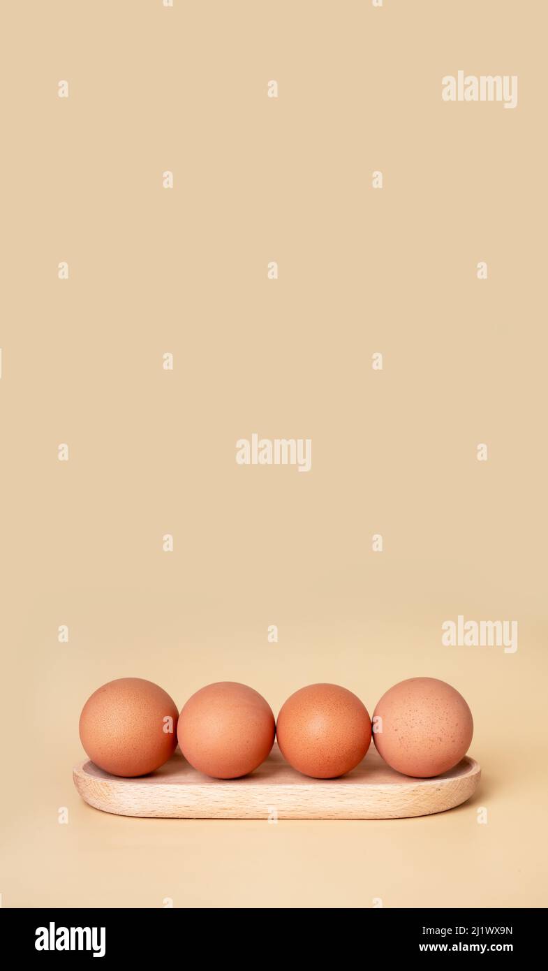 Banner mit gekochten Eiern am Holzserver. Osterkonzept. Copyspace auf beigefarbenem Hintergrund. Nahrhaftes landwirtschafthaftes Produkt. Hochwertige Fotos Stockfoto