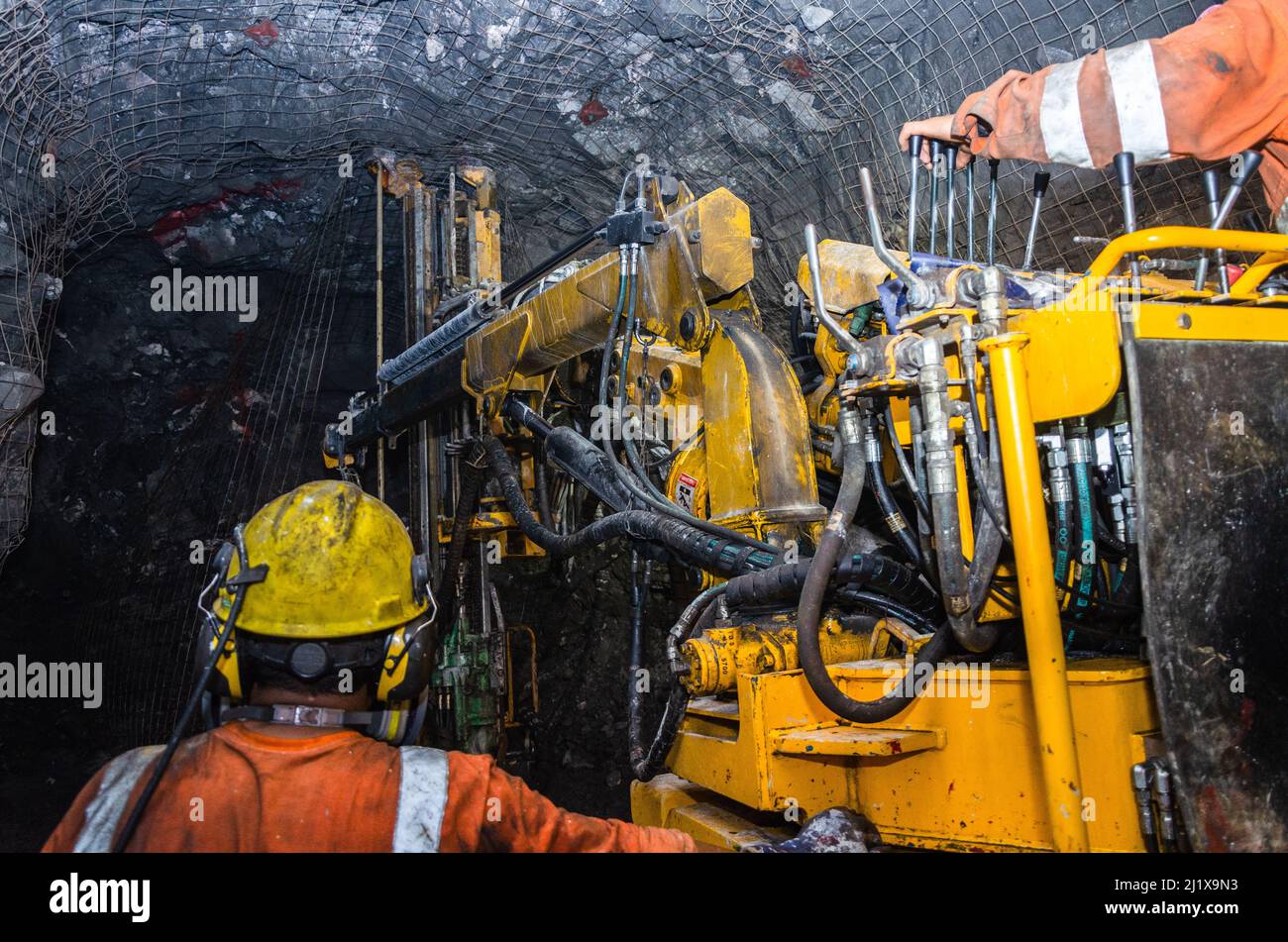 Bergbaubetreiber auf Bergbaumaschine, unterirdisches Minengeflecht Stockfoto Bergbaubetreiber auf Bergbaumaschine, unterirdisches Minengeflecht Stockfoto