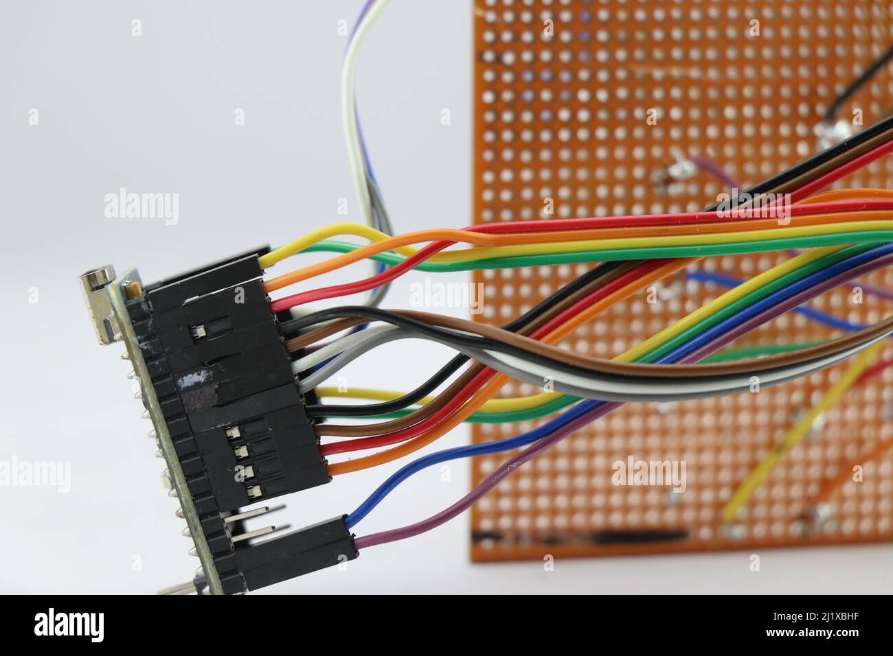 Jumper- oder Regenbogenfarben-Drähte stellen Verbindungen zwischen einer Null-Leiterplatte und einem Mikrocontroller her Stockfoto