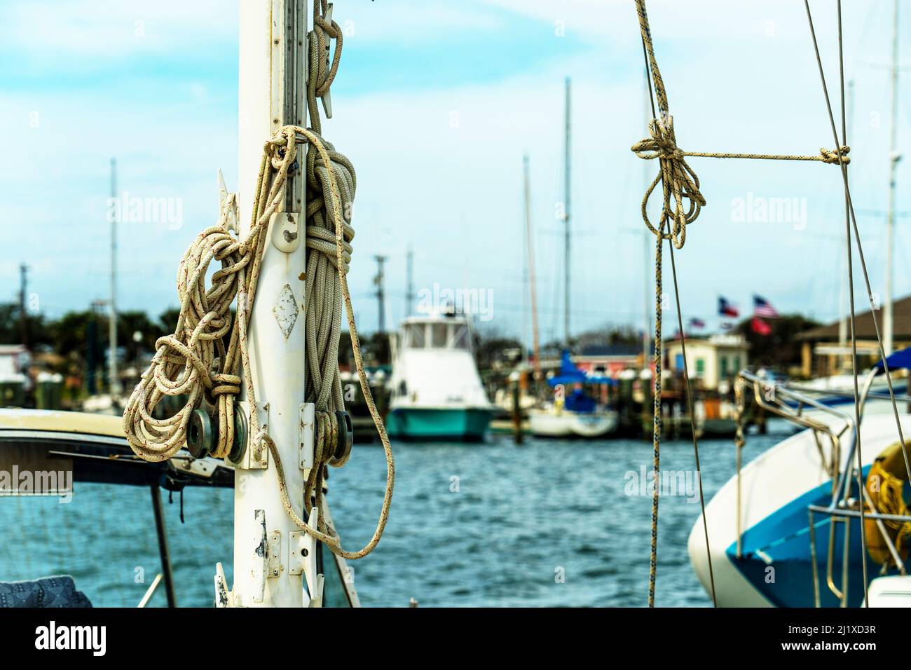 Verschiedene nautische Seile, die für den Einsatz am Mast eines Segelbootes in Amarina in Rockport, Texas, in Nahaufnahme mit begrenztem Fokus und geringer Schärfentiefe bereit sind. Stockfoto