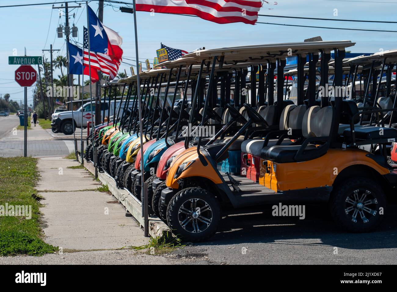 PORT ARANBAS, TX - 8 FEB 2020 - farbenfrohe Golfwagen, die am Bürgersteig aufgereiht und zur Miete bereit sind, sind ein beliebtes Transportmittel der VA Stockfoto